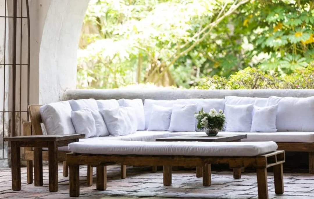 Sala lounge de madera con cojines blancos para evento