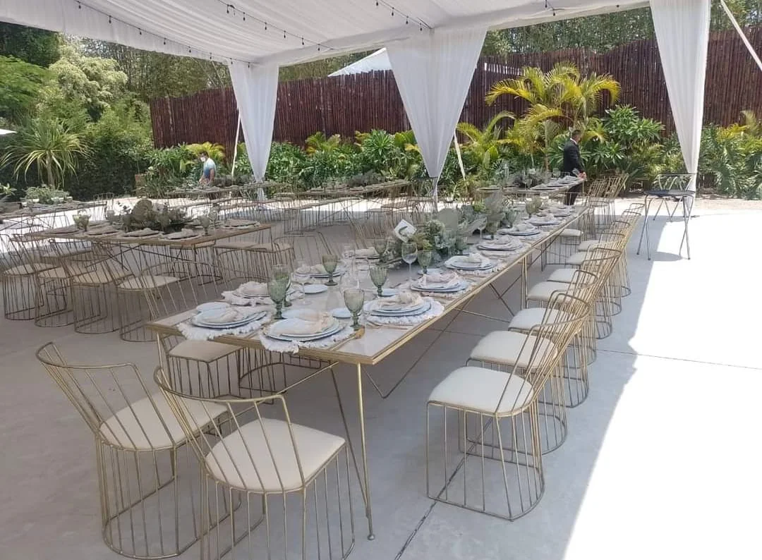 Mesas largas y sillas doradas para banquete al aire libre